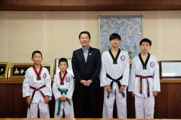 表敬訪問されたテコンドー選手と市長との記念写真